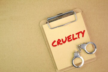 iron handcuffs and bookmarks with the word cruelty or violence. the concept of violence