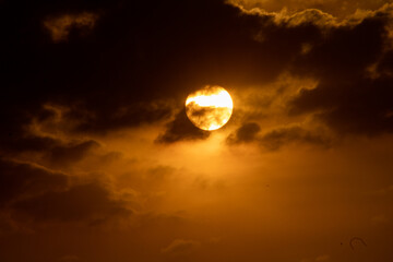 Atardecer, sol rodeado de nubes