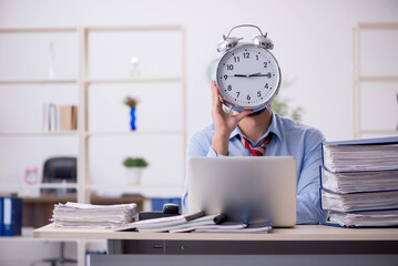 Young male employee in time management concept