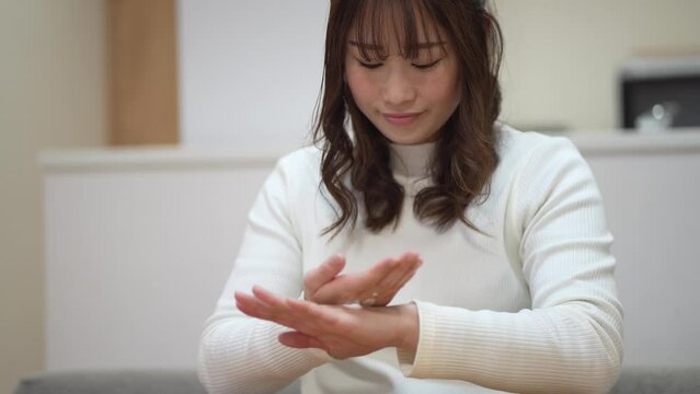 手に保湿クリームを塗る女性