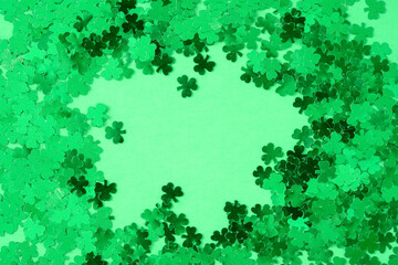 Green shamrock confetti on green as a St. Patrick’s Day background
