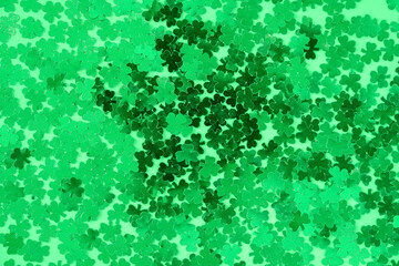 Obraz premium Green shamrock confetti on green as a St. Patrick’s Day background 