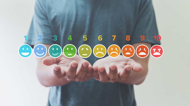 Man Holding of pain measurement scale colorful icon virtual screen interface, emotions from happy blue to red crying, medical technology and futuristic concept..