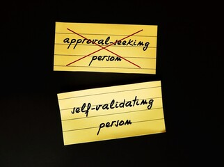 Stick note on black background with text written APPROVAL SEEKING PERSON crossed off to...