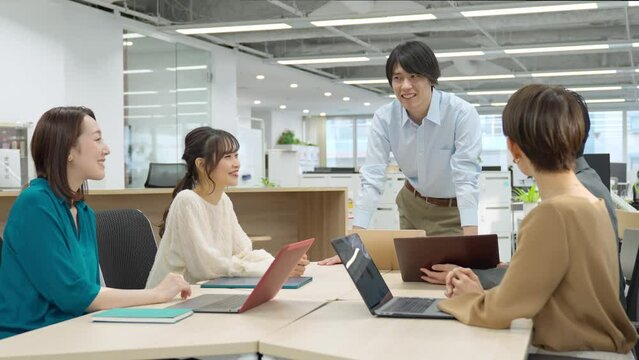 ビジネスカジュアルの服装で会議をする複数の日本人