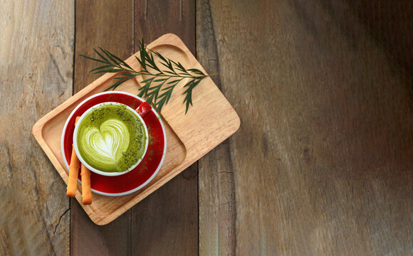 Green tea latte on a cup of wooden table. top view