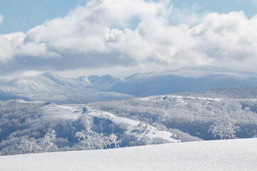 Snowy winter mountain landscape and white clouds on sunny day in Hokkaido backcountry  Japan