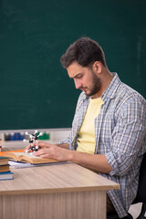 Young male physicist student in the classroom