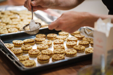 Selbstgemachte Linzeraugen werden mit Staubzucker bestreut