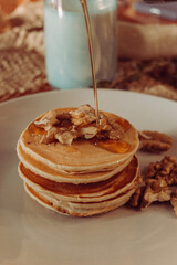 A stack of pancakes with walnuts in syrup