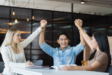 Team of colleagues man and women success project planing work and raising their hands in office. Group of business man and women successful training or meeting together in the office