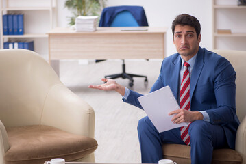 Young male employee sitting in the office