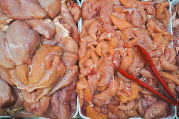 Photo of raw chicken portions for cooking and barbecuing with skinless breasts and diced strips for...