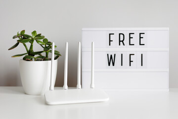White router, plant and lightbox with free wifi text