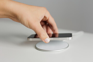 Hand putting mobile phone on wireless charger
