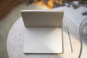 open blank notebook with pen on stone table with sunlight