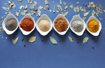 Spices close-up on blue background with laurel leaf. 
