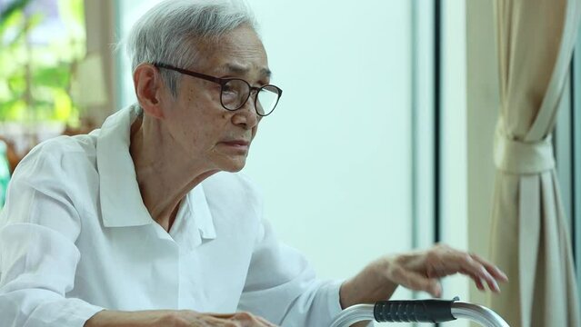 Sad asian senior woman crying alone at home,Unhappy female patient wiping the tears from eyes,Lonely old elderly,depressive illness,Depressed people with depression,mental health,health care concept