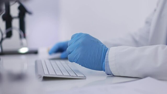 Doctor, hands and gloves typing on keyboard for research, medical data or browsing on computer at office desk. Hand of healthcare professional or scientist working on PC for online science discovery