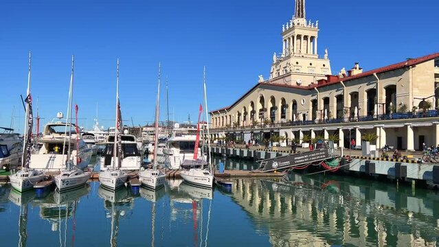SOCHI, RUSSIA - January 2023: Marine Station. View of the commercial Sea port of Sochi. The building of the Marine Passenger Terminal is reflected in the water. A seaport on the Black Sea.