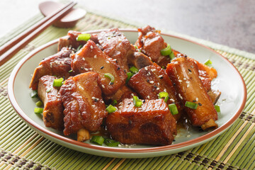 Glazed pork short ribs in sweet and sour sauce in Asian style close-up in a plate on the table. horizontal