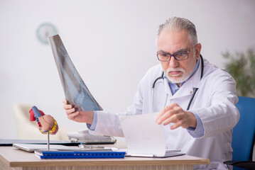 Old male doctor radiologist working at the hospital