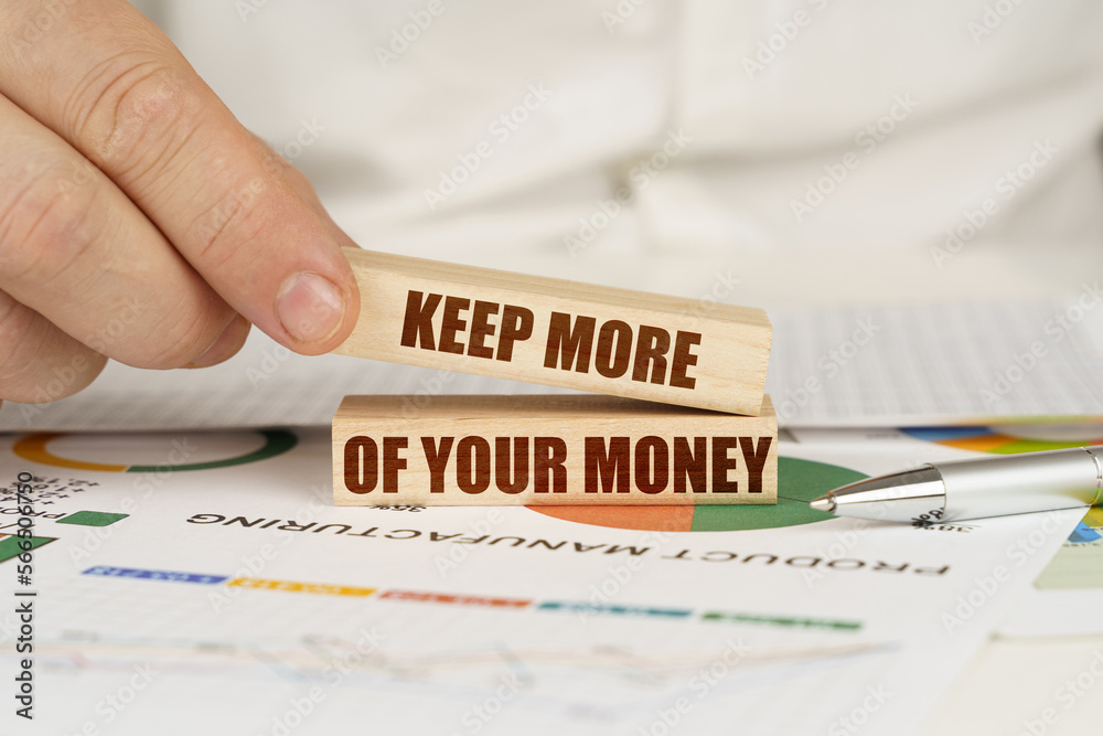 Wall mural on the table are business charts in the hands of a wooden block with the inscription-keep more of yo