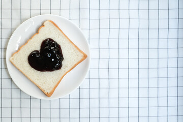 Bread with jam in shape of heart on white plate, Homemade bread for breakfast in the morning.