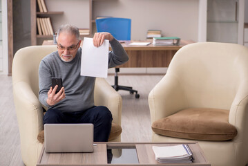Fototapeta premium Old male employee working from home during pandemic