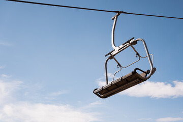 Empty chairlift with sky background in mountains