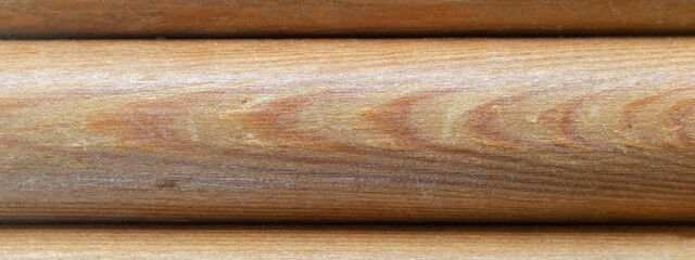 Textured background of a wooden round bar. Wood texture background board of rounded logs