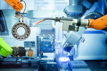 Close-up industrial welding robotics working with metalwork on smart factory with blue tone background, industry 4.0 and automation working via no people control 