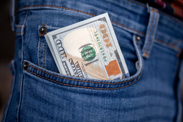 Many dollar 100 banknotes in a jeans pocket. One hundred dollar bills in a pocket of favorite trousers.