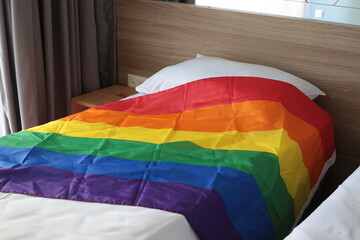 Rainbow Lgbtq  flag laying on the bed.