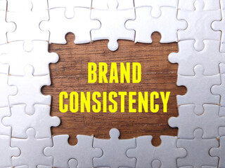 White puzzle with the word BRAND CONSISTENCY. Business concept.