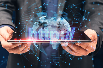 Close up of businessman hand holding tablet with glowing globe hologram on blurry background. Internet, big data, seo, security, web and technology concept. Double exposure.