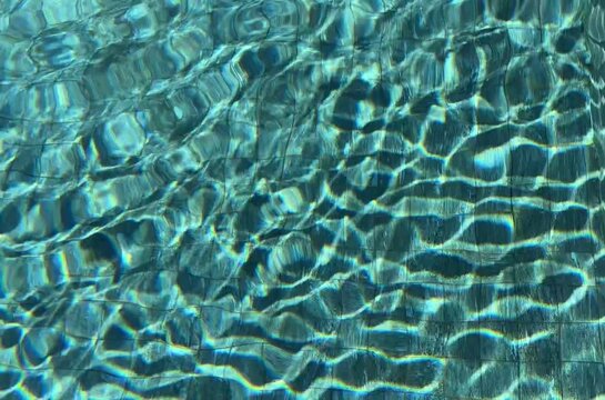 Pure blue water in the pool with light reflections. Slow motion. HD