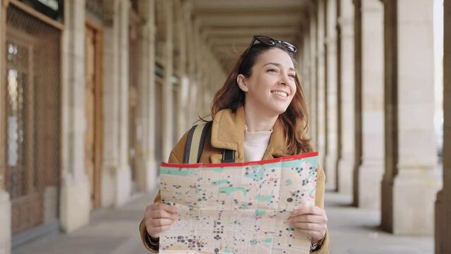 Young woman checking city map in winter vacations, exploring and visiting historical European town 