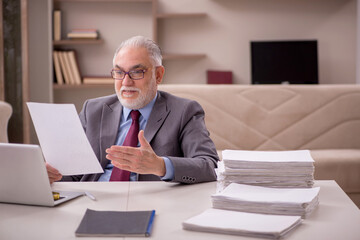 Old male employee working from home during pandemic