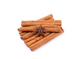 Group of cinnamon sticks with a single anise star. White background.