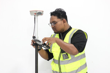 An asian male land surveyor operates a GNSS tool that is used to measure land with a satellite...