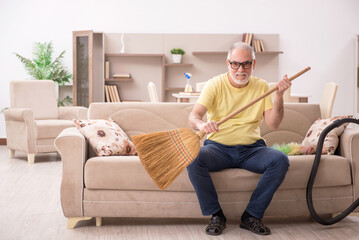 Old man doing housework at home
