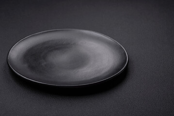 Empty ceramic round plate on dark textured concrete background