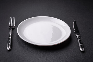 Empty ceramic round plate on dark textured concrete background