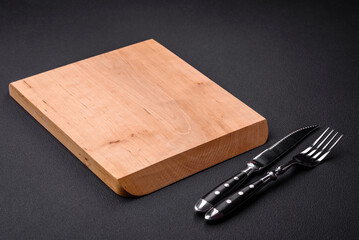 Empty wooden cutting board on dark textured concrete background