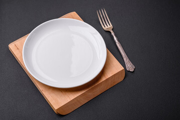 Empty ceramic round plate on dark textured concrete background