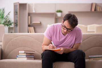 Fototapeta premium Young male student preparing for exams at home