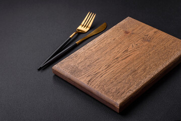 Empty wooden cutting board on dark textured concrete background