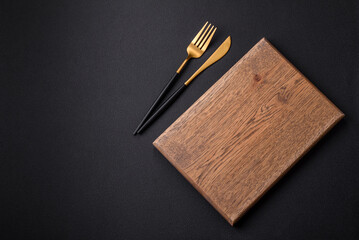 Empty wooden cutting board on dark textured concrete background