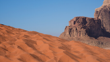 Red sand dunes and rugged mountainous landscape in vast, remote Wadi Rum desert in Jordan, Middle East